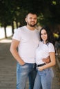 Handsome man with his gorgeous girlfriend. Happy couple walking along the embabkment. Green background