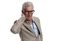 handsome man in his 60s with glasses holding hand behind neck Royalty Free Stock Photo