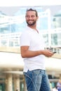 Handsome man holding cellphone outside Royalty Free Stock Photo