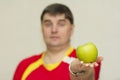 handsome man holding a green apple in his hands