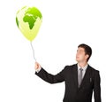 Handsome man holding a green globe balloon Royalty Free Stock Photo