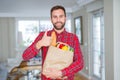 Handsome man holding groceries bag happy with big smile doing ok sign, thumb up with fingers, excellent sign Royalty Free Stock Photo