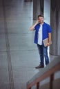 Handsome man holding laptop and talking on mobile phone Royalty Free Stock Photo