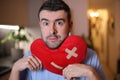Handsome man holding a mended heart Royalty Free Stock Photo
