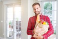 Handsome man holding paper bag full of fresh groceries at home Royalty Free Stock Photo