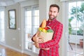 Handsome man holding paper bag full of fresh groceries at home Royalty Free Stock Photo