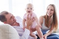 Handsome man holding smiling toddler while sitting with wife on Royalty Free Stock Photo