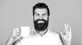 Handsome man holds cup of coffee, tea. Bearded man smiling showing sign ok. Good morning, man tea, ok. Smiling hipster Royalty Free Stock Photo