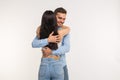 Handsome man hugging his girlfriend on white background