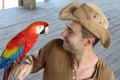 Handsome man interacting with a macaw Royalty Free Stock Photo