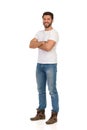 Handsome Man In Jeans And White T-shirt Is Standing With Arms Crossed, Smiling And Looking At Camera Royalty Free Stock Photo