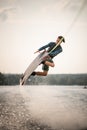 handsome man jumps spectacularly on wakeboard above the water with splashes Royalty Free Stock Photo