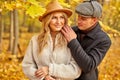 Handsome man is kind to his wife, love story in autumn forest or park Royalty Free Stock Photo