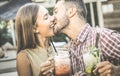 Handsome man kissing young woman at fashion cocktail bar