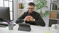 Handsome man laughing during coffee break in modern office setting Royalty Free Stock Photo
