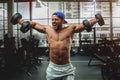 Handsome man lifting dumbbells at gym.