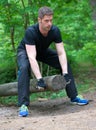 Handsome man lifting log. Royalty Free Stock Photo