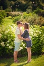 Handsome man is listening to his beautiful pregnant wife`s tummy and smiling Royalty Free Stock Photo