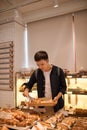 Handsome man at the local bakery store holding a tray with buns Royalty Free Stock Photo