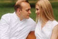 Handsome man look on his beautiful woman. Close up view Attractive couple sits on the bench in the park. Blonde hair man Royalty Free Stock Photo