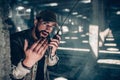 Handsome man is looking straight on camera. He is holding portable radio and talking to it. Also he is showing his right Royalty Free Stock Photo