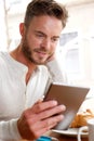 Handsome man looking at tablet over breakfast Royalty Free Stock Photo