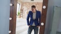 A handsome man looks in the mirror. A side view of a young man in a mirror in a modern bedroom Royalty Free Stock Photo