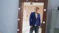 A handsome man looks in the mirror. A side view of a young man in a mirror in a modern bedroom Royalty Free Stock Photo