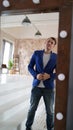 A handsome man looks in the mirror. A side view of a young man in a mirror in a modern bedroom Royalty Free Stock Photo