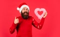 Handsome man love winter holidays red background. Merry christmas and happy new year. Guy wear Santa hat. Fall in love
