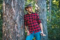 Handsome man lumberjack with a large ax examines the tree before felling. Agriculture and forestry theme. Logging. Royalty Free Stock Photo