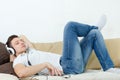 Handsome man lying on couch with headset listening to music Royalty Free Stock Photo