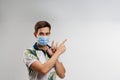 Handsome man in medical mask points up. Quarantine covid-19 period. Man weared t-shirt isolated white background Royalty Free Stock Photo