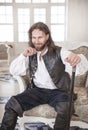 Handsome man in medieval clothes sitting in the chair Royalty Free Stock Photo