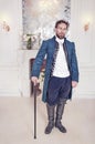 Handsome man in medieval clothes standing in the room Royalty Free Stock Photo