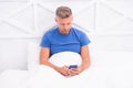 Handsome man online dating. relaxed male in bedroom. guy enjoying internet. social media addiction. cell phone addict Royalty Free Stock Photo