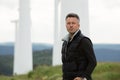 Handsome man. Outdoor male portrait over landscape with wind turbines. Wind generators. Wind turbine generators. Alternative Royalty Free Stock Photo