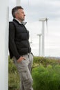 Handsome man. Outdoor male portrait over landscape with wind turbines. Wind generators. Wind turbine generators. Alternative Royalty Free Stock Photo