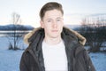 Handsome man outdoor in winter view fjord in Norway by a lake