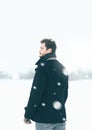 Handsome man outdoors standing in the winter blizzard