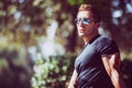 Handsome man outdoors with sunglasses, black t-shirt. Serious and relaxed look Royalty Free Stock Photo