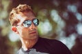 Handsome man outdoors with sunglasses, black t-shirt. Serious and relaxed look Royalty Free Stock Photo