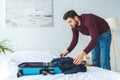 handsome man packing clothes into travel bag Royalty Free Stock Photo