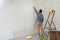 Handsome man painting wall with roller brush. Renovation house Royalty Free Stock Photo