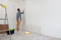 Handsome man painting wall with roller brush. Renovation house Royalty Free Stock Photo