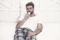 handsome man in pajama with remote control. guy watching television in bedroom. lazy sunday at home. watch morning show Royalty Free Stock Photo