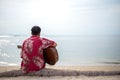 Handsome man playing classic guitar sitting on the beach in vacations Royalty Free Stock Photo