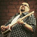 Handsome man playing his cigar box guitar Royalty Free Stock Photo