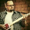 Handsome man playing his cigar box guitar Royalty Free Stock Photo