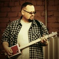 Handsome man playing his cigar box guitar Royalty Free Stock Photo